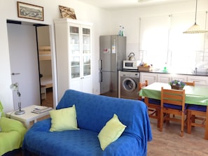 Cozy living space with a kitchenette, sofa, and dining area.