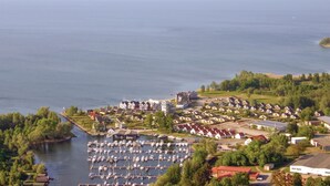 A marina with numerous boats docked, surrounded by residential buildings with red roofs and white walls. - Cozy apartment in Rechlin (Rechlin)