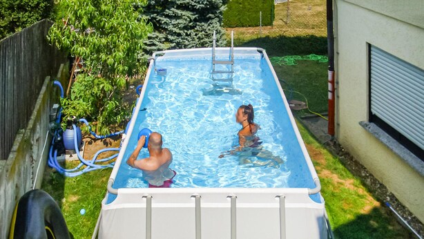 A rectangular above-ground pool with a ladder, surrounded by a grassy yard and a wooden fence. - Lovely apartment in brensbach ot wersau (Brensbach OT Wersau)