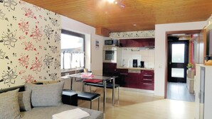 A modern kitchen with a dining area, a sofa with a blanket, and a window with curtains. - Lovely apartment in brensbach ot wersau (Brensbach OT Wersau)