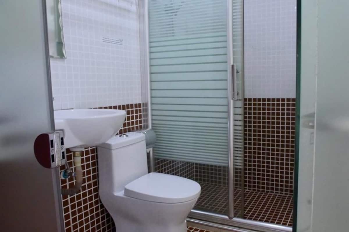 A bathroom with a toilet, a sink, and a shower enclosure.