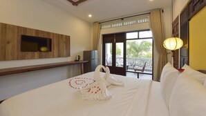 Een hotelkamer met een bed, een aan de muur bevestigde televisie, een balkon met uitzicht en een kroonluchter.
