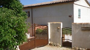A rustic building with a gated entrance, a small window, and a sign on the wall. - Nice cottage in the Luberon Regional Park (Viens)