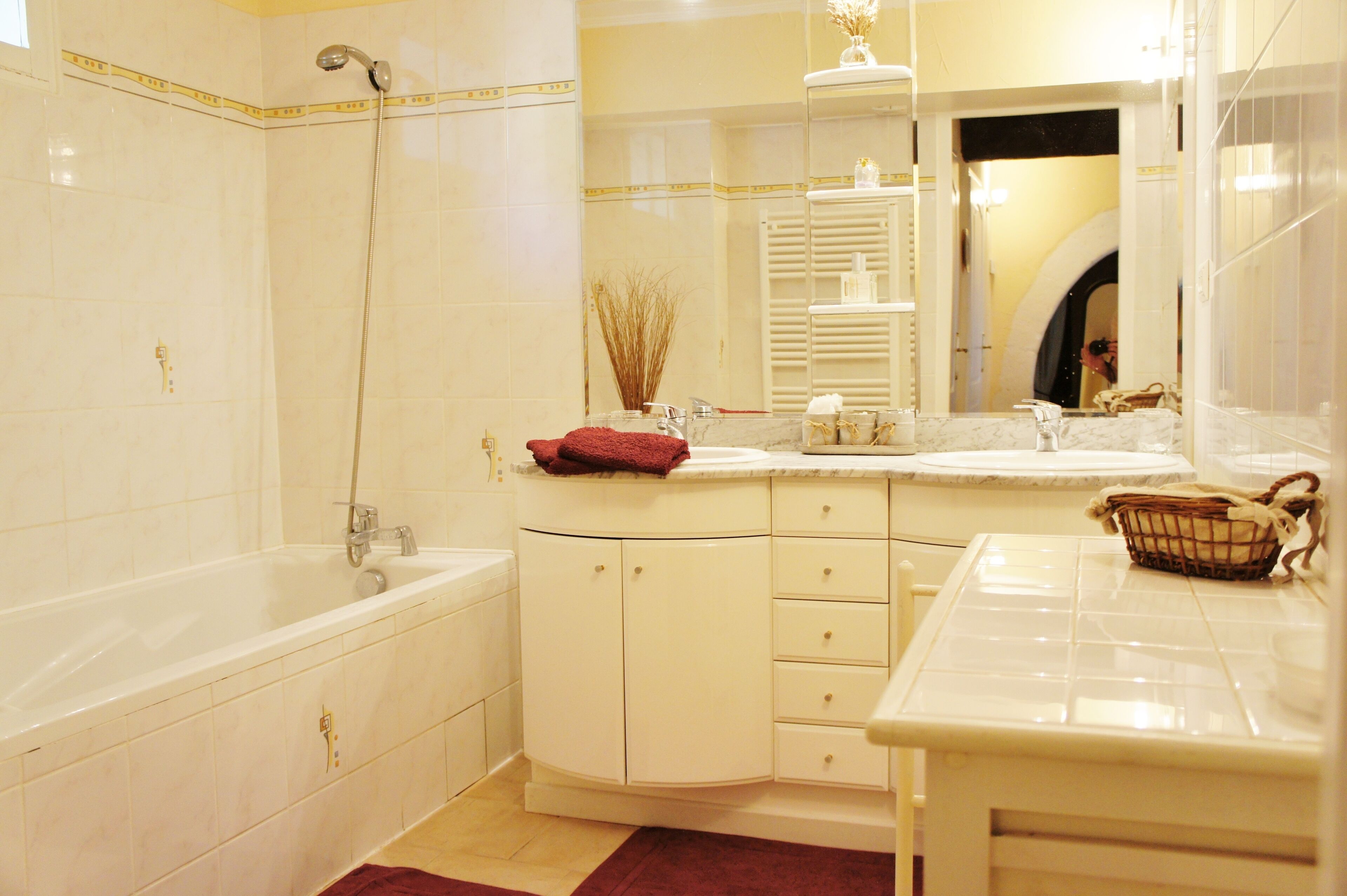 Une salle de bain avec une baignoire, un lavabo et un miroir.