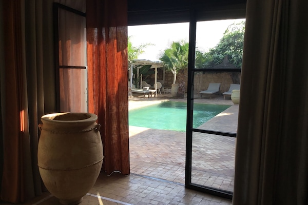 Vue féerique sur le jardin et la piscine à débordement