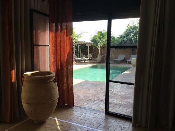 A view of a swimming pool area with a large pot in the foreground.