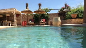 A clear pool with stone walls and traditional thatched umbrellas. - Casbah d'architecte,Chic et Luxe, 305 comments 5*,Optional meals and massages (Essaouira)