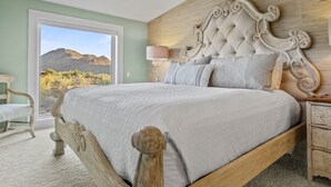 Un dormitorio con una cama grande, cabecera de madera, una mesita de noche y una lámpara.