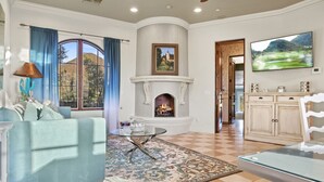 Una sala de estar con chimenea, televisión y vista al exterior.