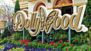 A sign for 'Dolly Food' with a stylized logo and a garden with colorful flowers in front. - Gatlinburg Cabin 4BR 2.5BA Hot Tub 7 Beds Low Cleaning Fee Smoky Mountains Dolly (Gatlinburg)