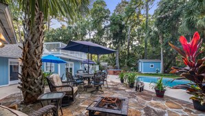 A patio area with stone flooring, wicker furniture, a fire pit, and a pool. -  VACAY TIME:HHI Retreat: Pool/Hot Tub/Near Beach, Pets, Last Minute Rentals Now! (Hilton Head Island)