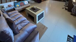 A spacious living room with a modern chandelier, a staircase, and a cozy seating area with a coffee table.