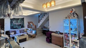 A spacious living area with a sofa, coffee table, and a glass cabinet filled with collectibles.