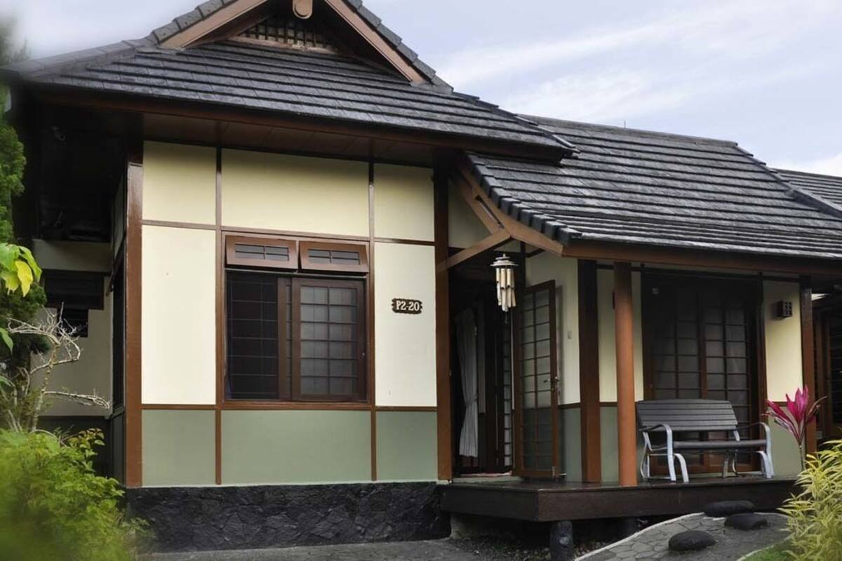 A traditional Japanese-style building with a tiled roof, a small porch with a bench, and a number plaque indicating room number P2.20.