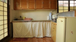 Una cocina con armarios de madera, un refrigerador y un ventanal con vistas.