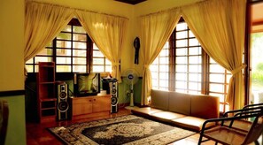 Una sala de estar acogedora con un sofá, una mesa de centro, un televisor y un equipo de sonido.