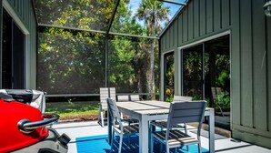 Une terrasse extérieure équipée d’un barbecue, d’une table et de chaises.