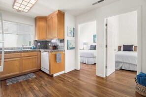 A compact kitchen with wooden cabinets, granite countertops, and a built-in oven.