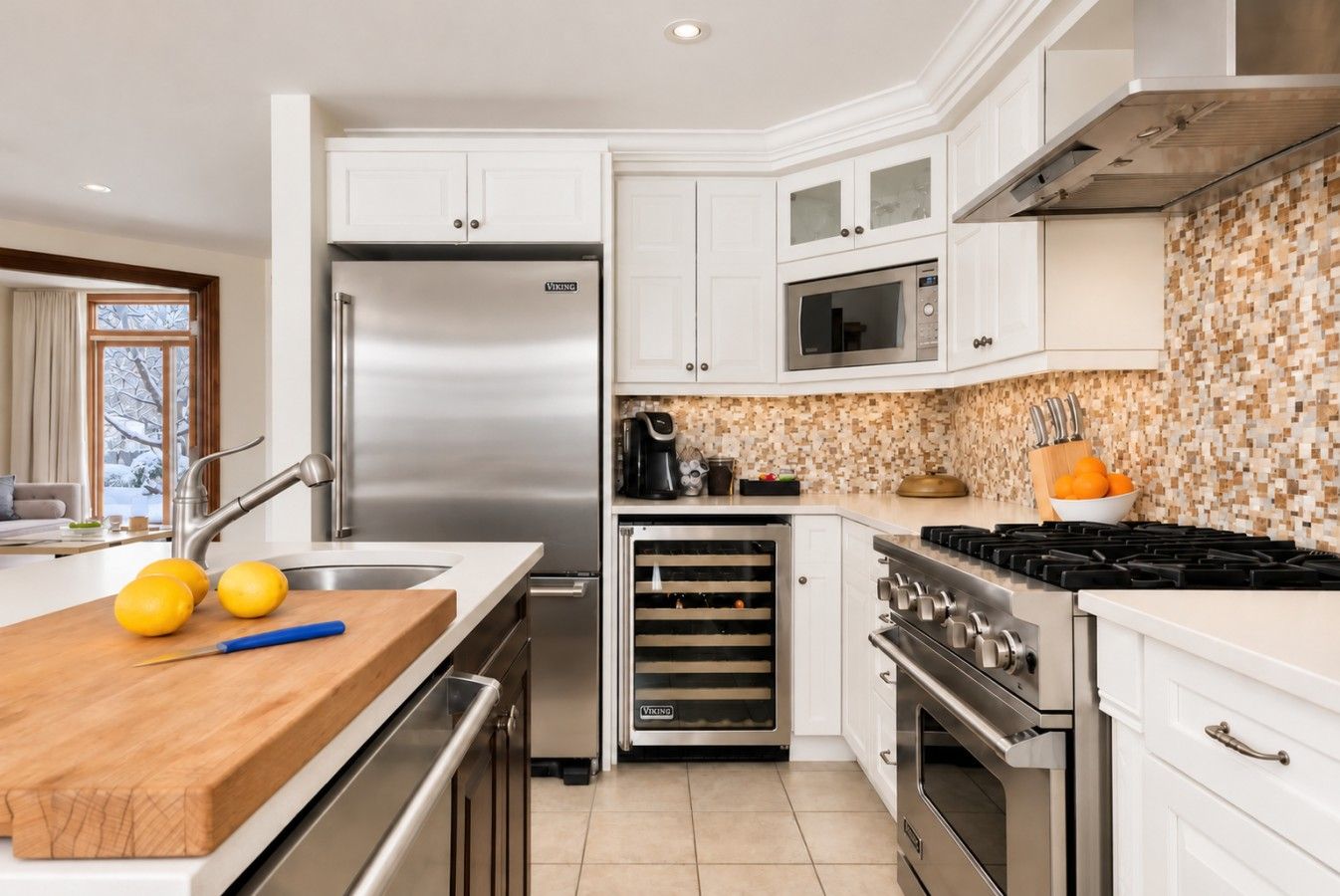 A modern kitchen with stainless steel appliances, a wooden countertop, and a tiled backsplash.