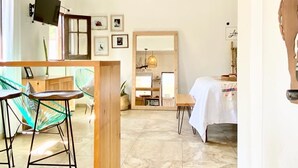 A room with a dining area, a bed, a television, and a ceiling fan. - Loreto80- NEW Studio Cactus, in downtown by beach (Loreto)