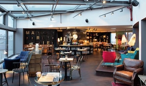 A modern interior with seating areas, tables, and a bar. - Ruby Marie Hotel Vienna by IHG (Vienna)