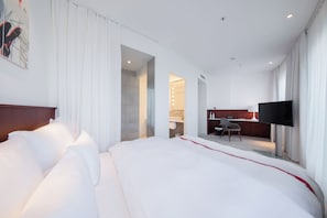 Una camera d'albergo moderna con un letto grande, una scrivania e una TV.