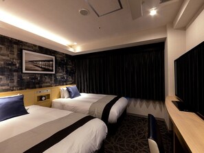 Une chambre d’hôtel avec deux lits, un bureau, une chaise, une horloge et un téléviseur fixé au mur.