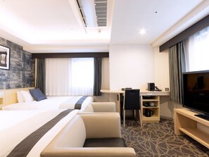 Une chambre d’hôtel équipée d’un lit, d’un bureau, d’une chaise, d’une télévision et d’une machine à café.