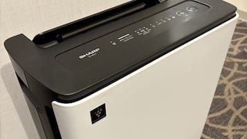 Una fotocopiadora Sharp con una parte superior negra, un panel de control con varios botones y una pantalla pequeña, y un cuerpo plateado.