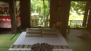Una habitación con cama, ventana y vistas al verdor exterior.