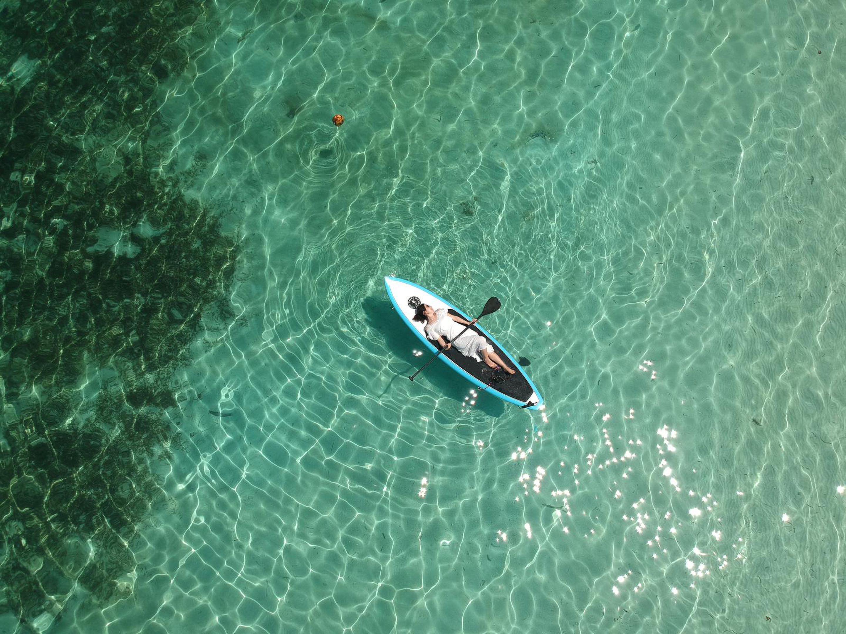 Si scorge un corpo d'acqua con una sola barca e una persona che pagaia.