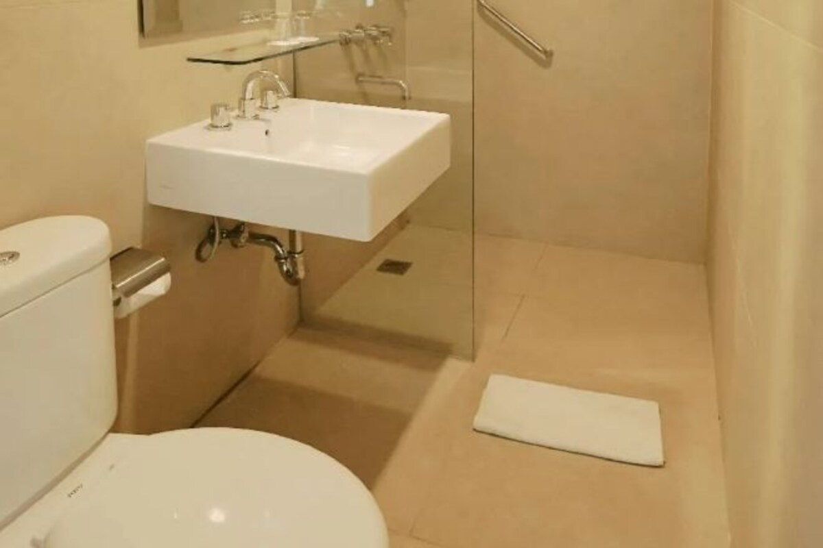 Un baño con inodoro, lavamanos y zona de ducha.