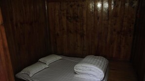 A single bed with white bedding in a room with wooden walls. - Ban Buoc Homestay - Hostel (Muong Bi)