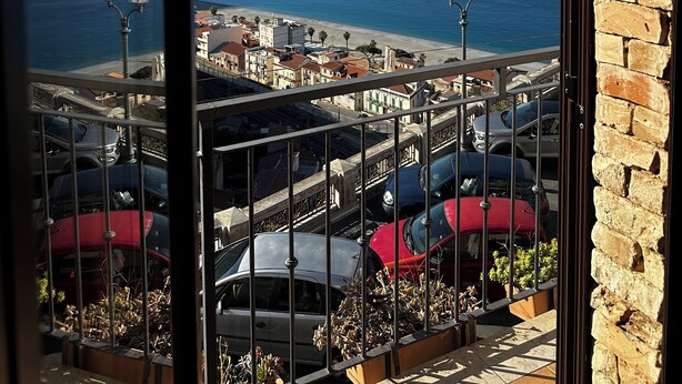 A balcony with a view of the sea, a beach, and a distant island. - B&B La Bastia  (Scilla)