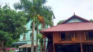Un bâtiment traditionnel avec un toit recouvert de tuiles rouges, un balcon et un petit porche.