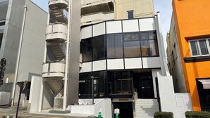 A multi-story building with a central spiral staircase, large windows, and a modern architectural design. - Utsunomiya Hotel Maruji (Utsunomiya)