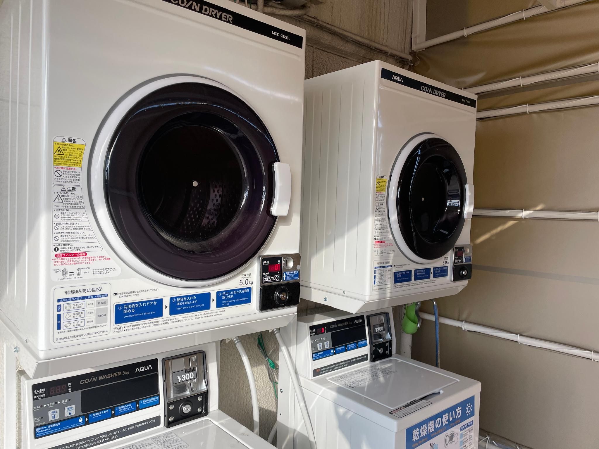 Two front-loading washing machines with digital displays and control panels, placed side by side.