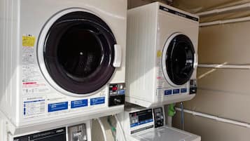 Two front-loading washing machines with digital displays and control panels, placed side by side.