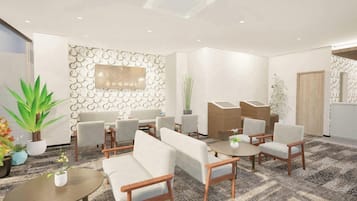 A modern reception area with a seating arrangement, a wall-mounted TV, and a patterned wall design.