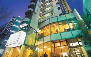 Un edificio moderno con varios pisos, grandes ventanales y fachada combinada de vidrio y metal.