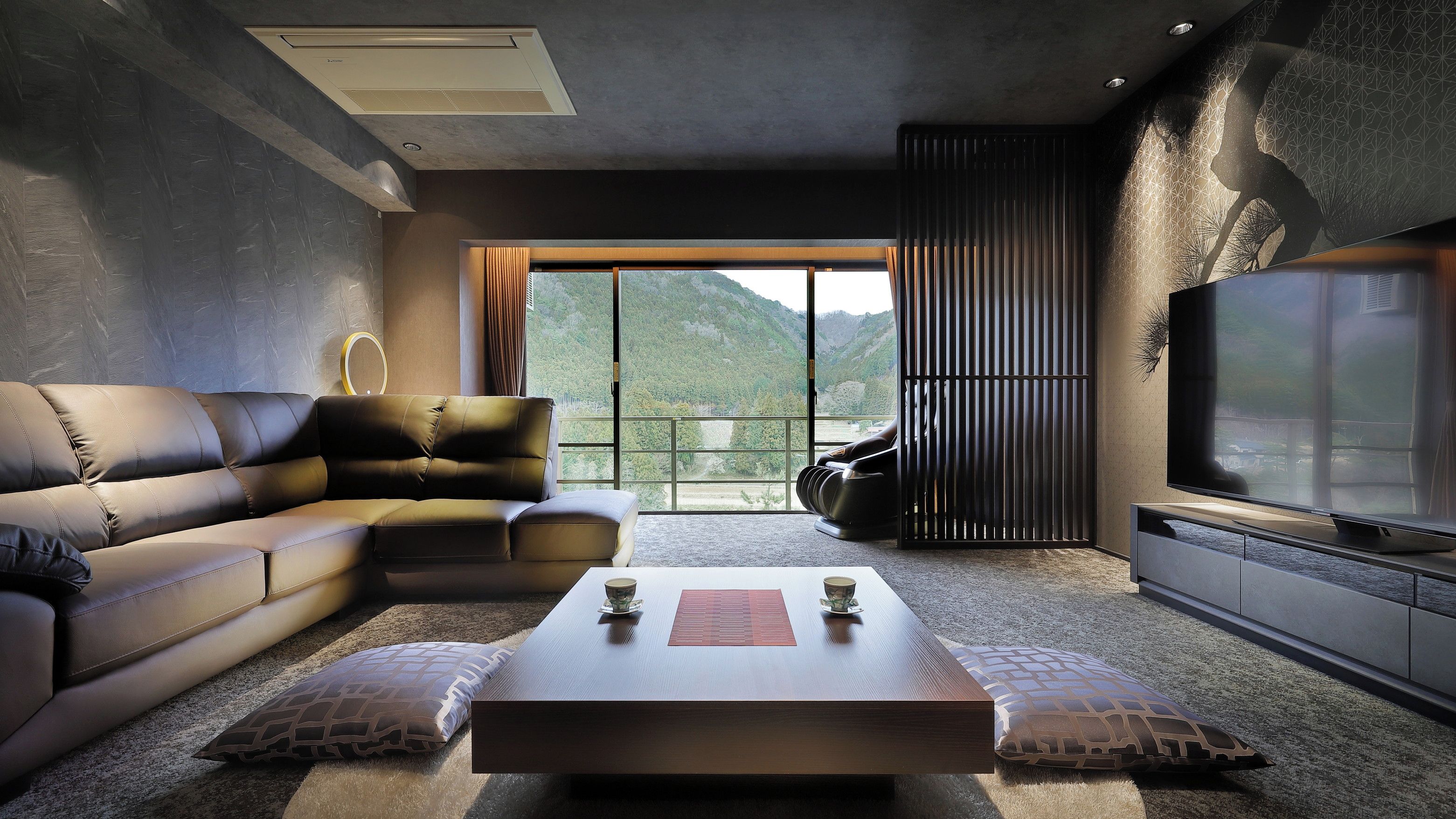 A modern living room with a sectional sofa, a coffee table, and a large TV.