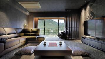 A modern living room with a sectional sofa, a coffee table, and a large TV.