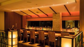 A bar area with multiple seating options and a well-stocked bar counter.