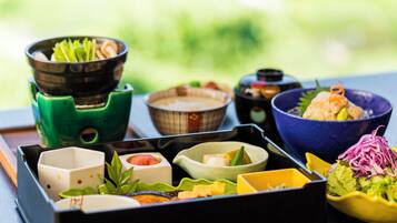 A traditional Japanese bento box with various food items and condiments.