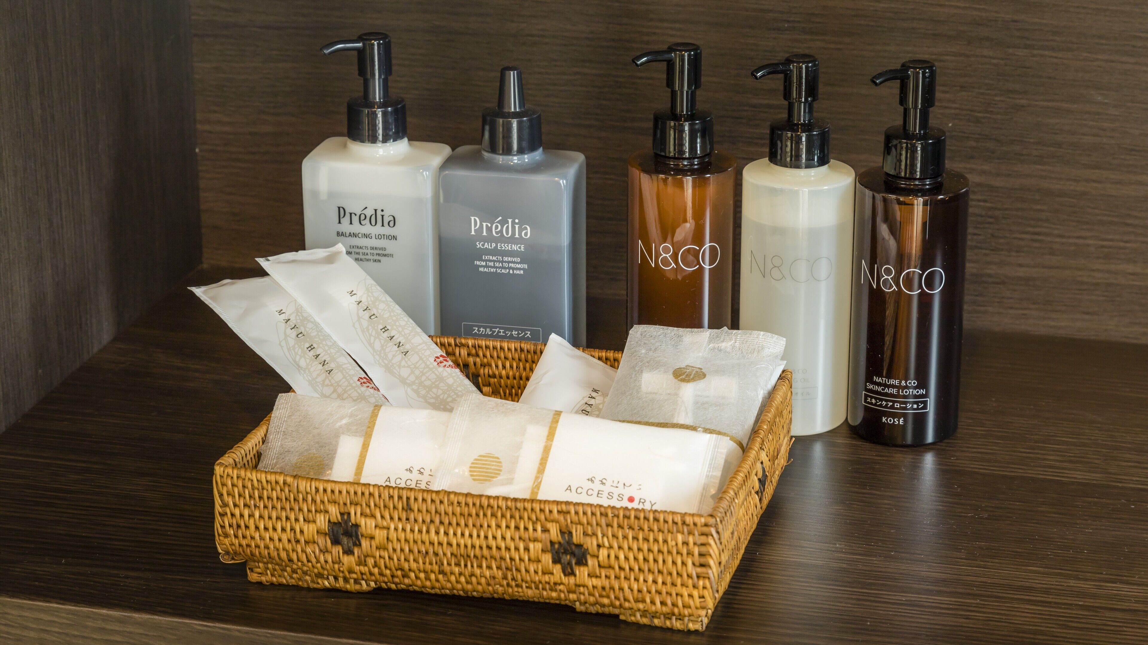 A wooden surface with a wicker basket containing various skincare products and a box labeled 'Prédia'.