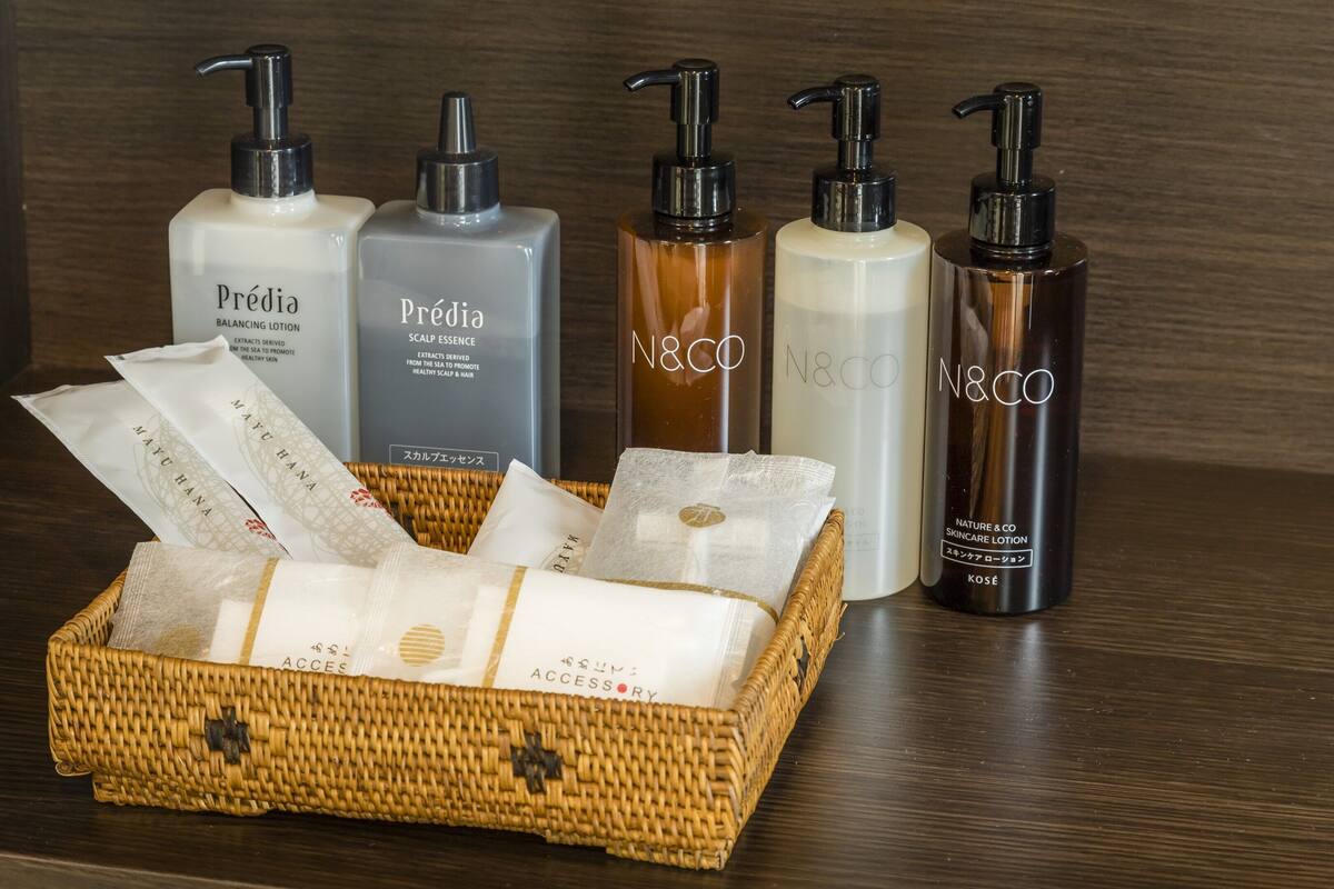 Une surface en bois sur laquelle se trouve un panier en osier contenant divers produits de soins pour la peau, ainsi qu’une boîte étiquetée « Prédia ».