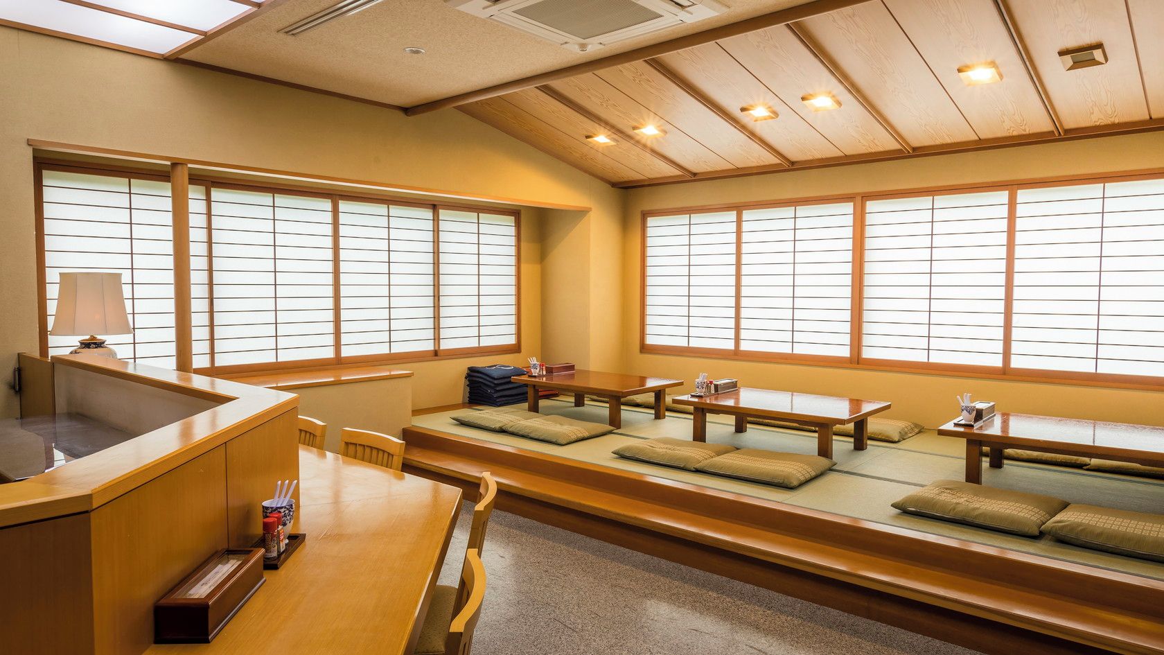 Una habitación tradicional japonesa con esteras de tatami, mesas bajas y puertas correderas de shoji.