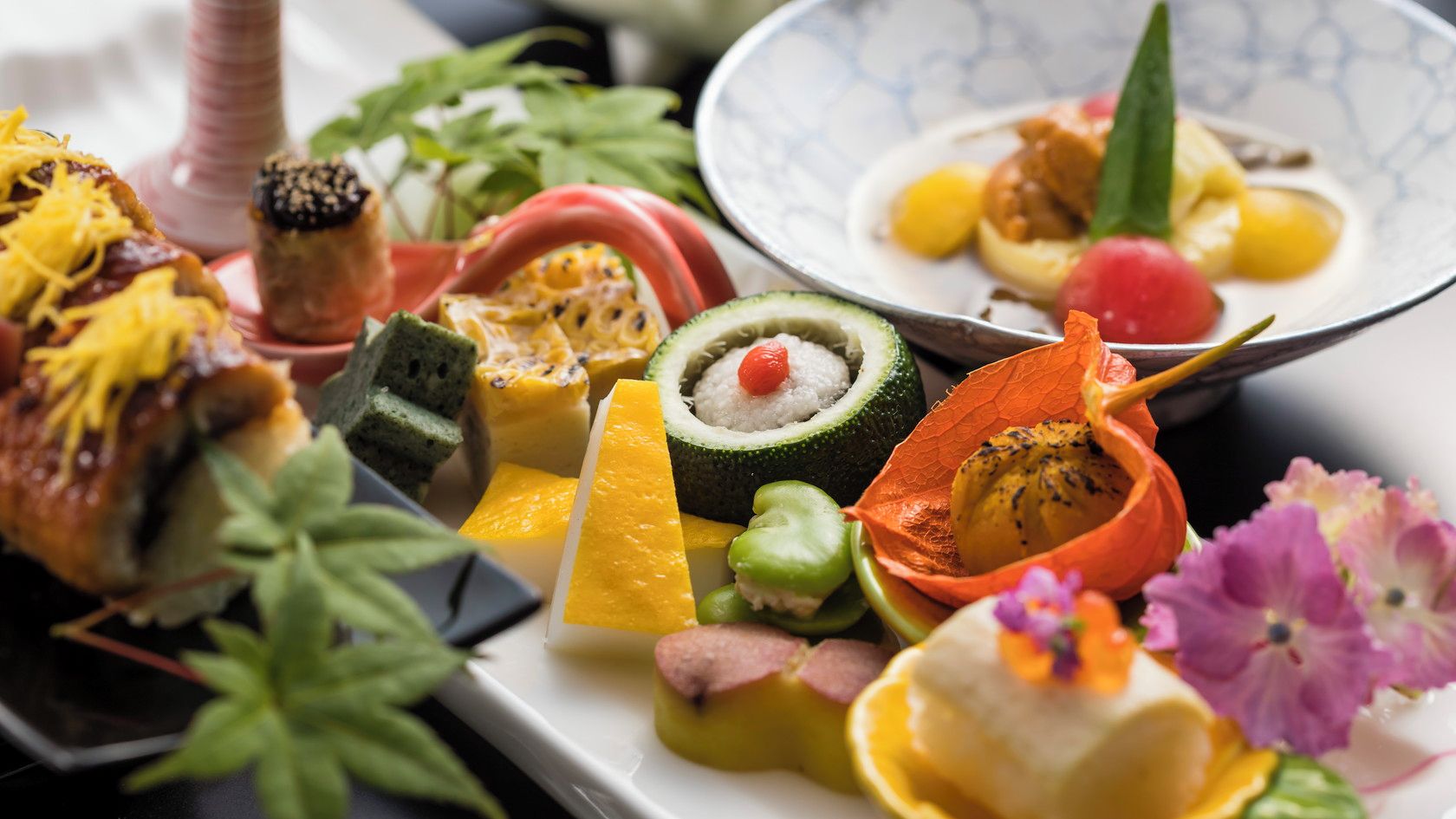 A variety of food items arranged on a plate, including what appears to be sushi, vegetables, and possibly some meat.