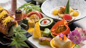 A variety of food items arranged on a plate, including what appears to be sushi, vegetables, and possibly some meat. - Wakatake no Sho (Nikko)