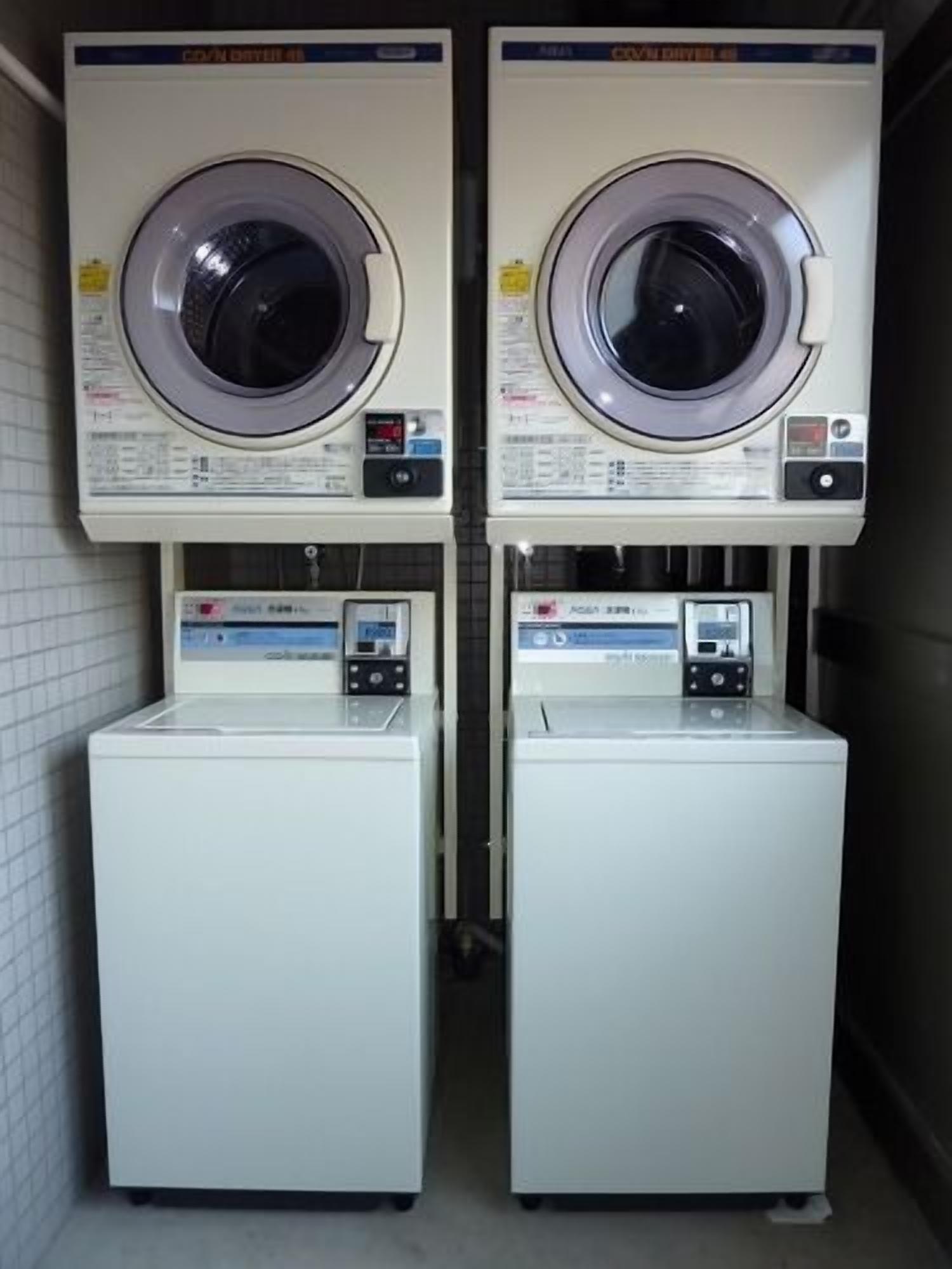 Two stacked washing machines in a narrow space.